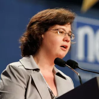 Alice O'Brien stands at a podium to speak