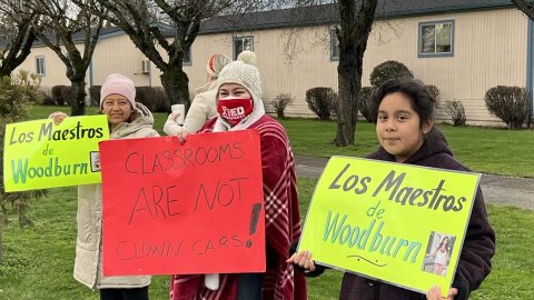 Woodburn teachers with signs saying classrooms are not clown cars